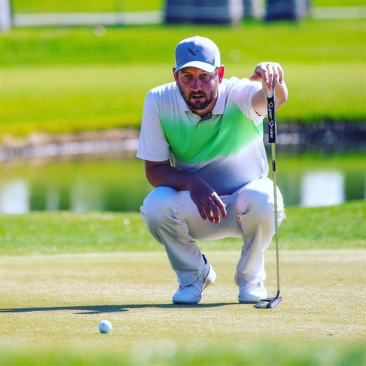 Tyler crouched on a green, reading a putt